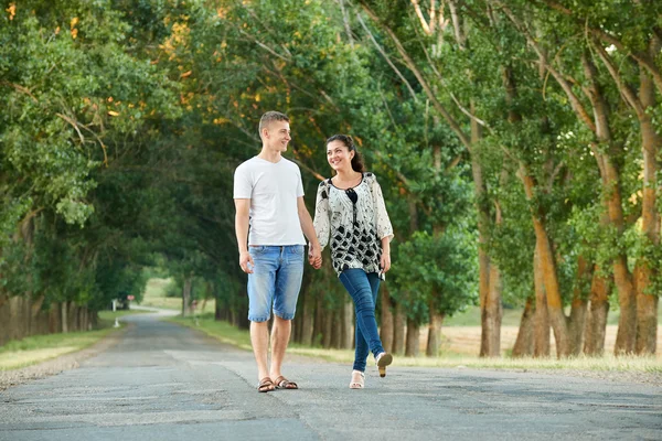 Heureux jeune couple marcher sur la route de campagne en plein air, concept de personnes romantiques, saison estivale — Photo