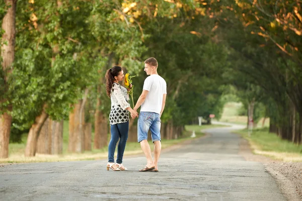 Щаслива молода пара гуляє по сільській дорозі на відкритому повітрі, концепція романтичних людей, літній сезон — стокове фото