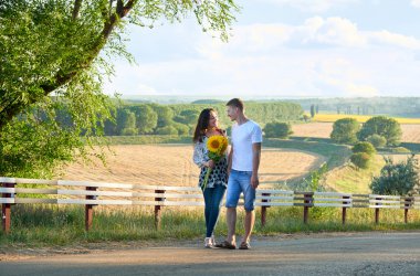 mutlu çift eğleniyor ve açık havada - ülke yol yürüyüş romantik seyahat, yürüyüş, turizm ve insanlar kavramı ayçiçeği ile