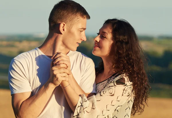 Joven pareja posando en campo al aire libre por la noche, romántico y tierno concepto, temporada de verano — Foto de Stock