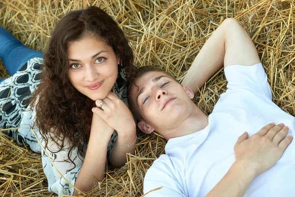Щаслива молода пара лежить в соломі, пшеничне поле ввечері, концепція романтичних людей, красивий пейзаж, літній сезон — стокове фото