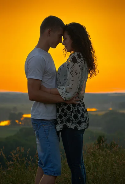 Romantic couple at sunset on bright yellow sky background, love — Stock Photo, Image