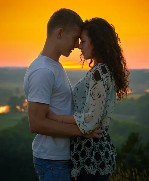 Romantický pár při západu slunce na zářivě žluté oblohy pozadí, lásce něhu koncept, mladých dospělých lidí — Stock fotografie