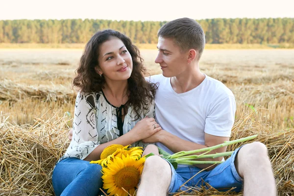 Feliz jovem casal sentar no campo de trigo à noite, conceito de pessoas românticas, bela paisagem, temporada de verão — Fotografia de Stock