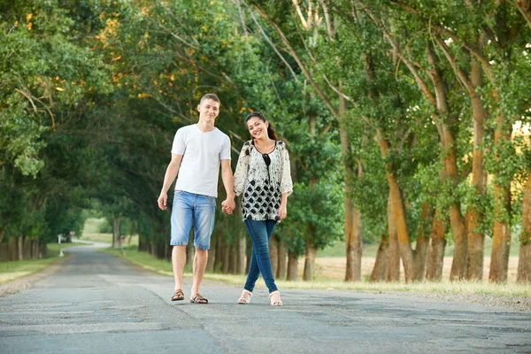 Felice giovane coppia passeggiata sulla strada di campagna all'aperto, romantico concetto di persone, stagione estiva — Foto Stock