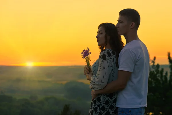 Romantyczna para patrzeć na słońce, wieczór na zewnątrz, piękne ziemie — Zdjęcie stockowe