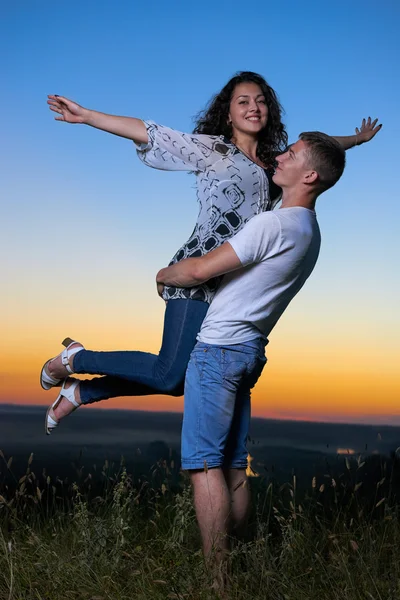 Romantický pár baví při západu slunce na přírodě, krásné krajiny a jasně žluté oblohy, lásce něhu koncept, mladých dospělých lidí — Stock fotografie