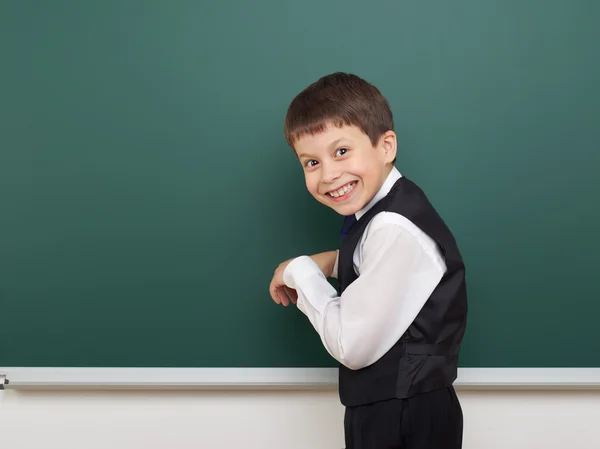 Estudiante de la escuela posando en la pizarra limpia, muecas y emociones, vestido con un traje negro, concepto de educación, foto de estudio —  Fotos de Stock