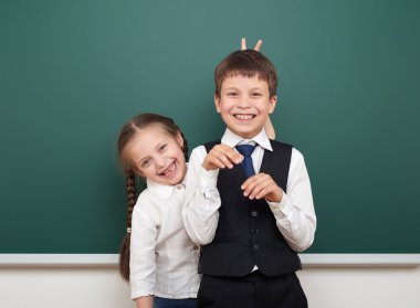 iki okul öğrenci temiz yazı tahtası, yapması ve duygular, poz giyinmiş bir siyah takım elbise, eğitim kavramı, studio fotoğraf