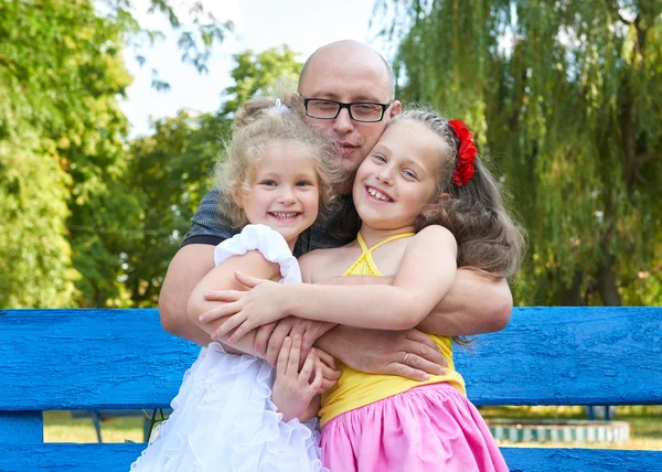 Father with children in park, happy family portrait, group of three peoples sit on bench, parenting concept — Stock Photo, Image