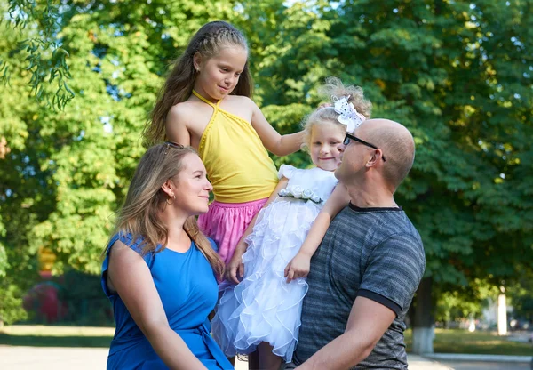 Happy family portrait on outdoor, group of four people posing in city park, summer season, child and parent — Stock Photo, Image