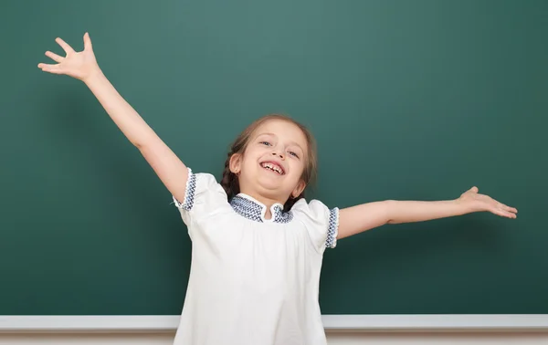 School student girl open arms at the clean blackboard, grimacing and emotions, dressed in a black suit, education concept, studio photo — Stock Photo, Image