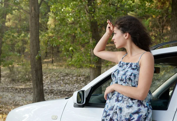 Девушка на сельской дороге с автомобилем, летний сезон — стоковое фото