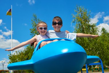 Mavi uçak cazibe park, mutlu çocukluk, yaz tatil kavramı iki childs anında
