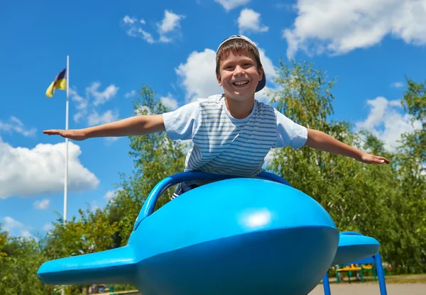 Niño vuela en la atracción azul del avión en el parque, infancia feliz, concepto de vacaciones de verano —  Fotos de Stock