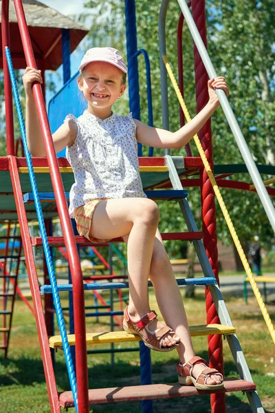 Bambino felice sul campo da giuoco all'aperto, giochi nel parco della città, stagione estiva, luce solare luminosa — Foto Stock