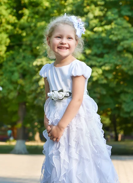 Child girl portrait, posing in white gown, happy childhood concept, summer season in city park — Stock Photo, Image