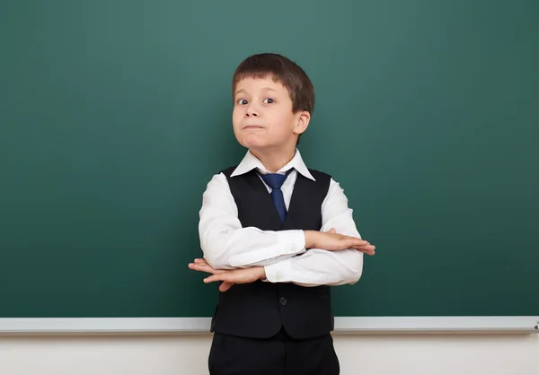 Schüler posiert an der sauberen Tafel, Grimassen und Emotionen, im schwarzen Anzug, Ausbildungskonzept, Studiofoto — Stockfoto