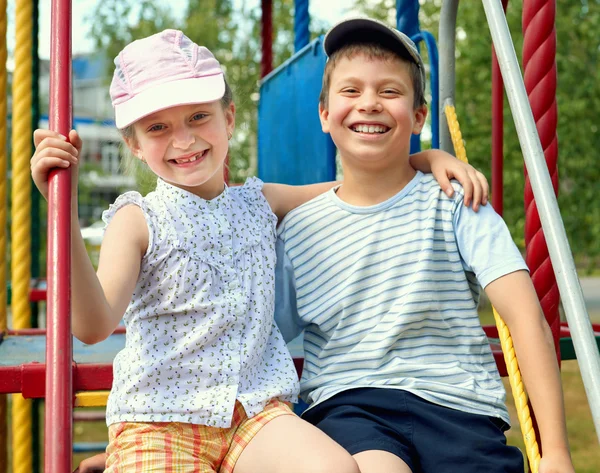 Criança feliz no campo de jogos ao ar livre, jogo no parque da cidade, estação de verão, luz solar brilhante — Fotografia de Stock
