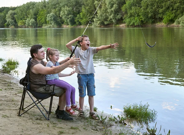 Mensen kamperen en vissen, familie actief in de natuur, vissen gevangen op aas, rivier en bos, zomerseizoen — Stockfoto