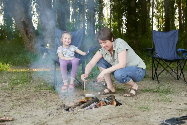 Femme cuisine, camping en forêt, famille active dans la nature, feu de joie, saison estivale — Photo