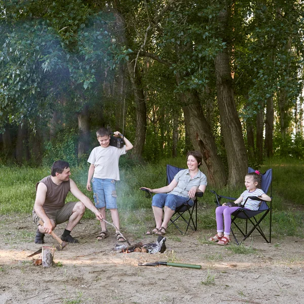 Persone campeggio nella foresta, famiglia attiva nella natura, accendere il fuoco, stagione estiva — Foto Stock