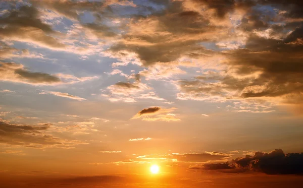 Sfondo cielo tramonto con nuvole, basso sole, colori rosso scuro e blu — Foto Stock