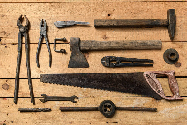 Variety of old vintage household hand tools still life on a wooden background in a DIY and repair concept