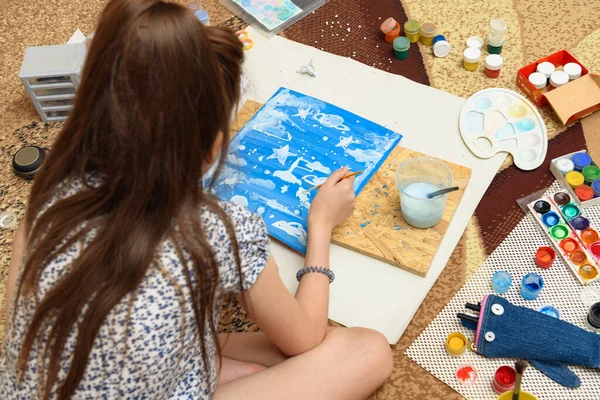 girl draws at home, artistic creation, makes creative artwork from paper, paints and brushes