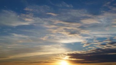 Güzel gün batımı gökyüzü zaman akıp gidiyor. Parlak güneş arka planda kalıyor.