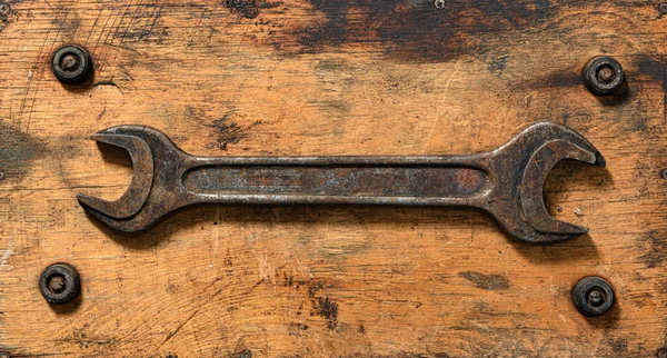 old vintage hand tool - one wrench on a wooden background, object in retro style