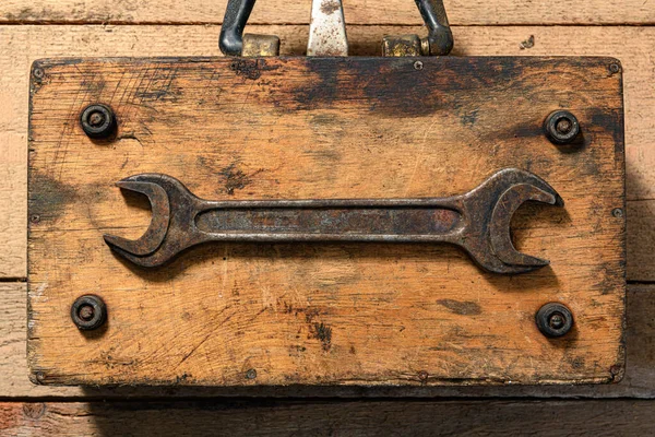 old vintage hand tool - one wrench on a wooden background, object in retro style