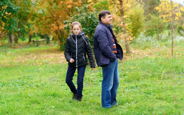 父亲和女儿在秋天的城市公园里散步 没有感情 也没有幸福 两人在一起散步 这是交流不畅的问题 — 图库照片