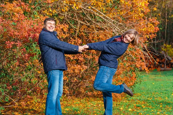 秋の都会の公園を歩いたり幸せな人たちと一緒に美しい色の葉で — ストック写真