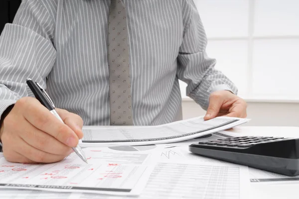 İş dünyası konsepti - iş adamının çalışma masası yakın görünümü, mali raporları kontrol etmesi, yazması ve sayması