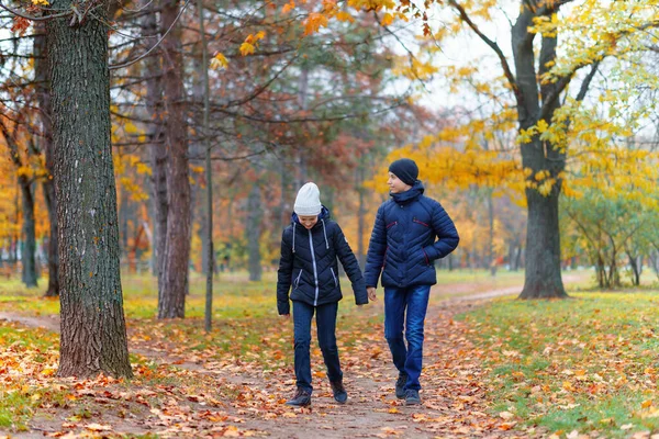 公園を歩いている10代の少女と少年黄色の葉で美しい秋を楽しむ — ストック写真