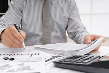 İş dünyası konsepti - iş adamının çalışma masası yakın görünümü, mali raporları kontrol etmesi, yazması ve sayması