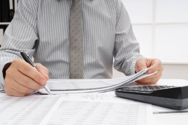 İş dünyası konsepti - iş adamının çalışma masası yakın görünümü, mali raporları kontrol etmesi, yazması ve sayması