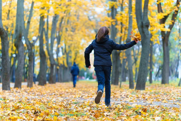少男少女在公园里跑来跑去 享受着秋天 美丽的大自然 还有黄叶 — 图库照片