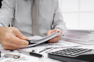 İş dünyası konsepti - iş adamının çalışma masası yakın görünümü, mali raporları kontrol etmesi, yazması ve sayması