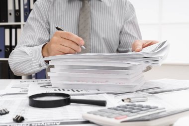 İş dünyası konsepti - iş adamının çalışma masası yakın görünümü, mali raporları kontrol etmesi, yazması ve sayması