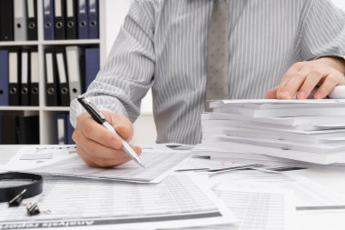 İş dünyası konsepti - iş adamının çalışma masası yakın görünümü, mali raporları kontrol etmesi, yazması ve sayması