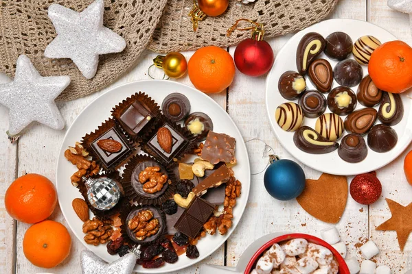 甘い食べ物のトップビューの背景メリークリスマスや新年の休日の装飾 白い木の上にチョコレートキャンディー みかん クッキー マシュマロとココアラテ — ストック写真