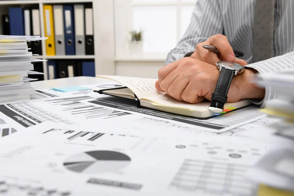 ビジネスコンセプト オフィスで働くビジネスマンや腕時計 テーブル ワークスペースをよく見る 財務報告書をチェックする 書き込みとカウント — ストック写真