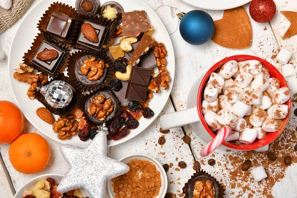 甘い食べ物のトップビューの背景メリークリスマスや新年の休日の装飾 白い木の上にチョコレートキャンディー みかん クッキー マシュマロとココアラテ — ストック写真