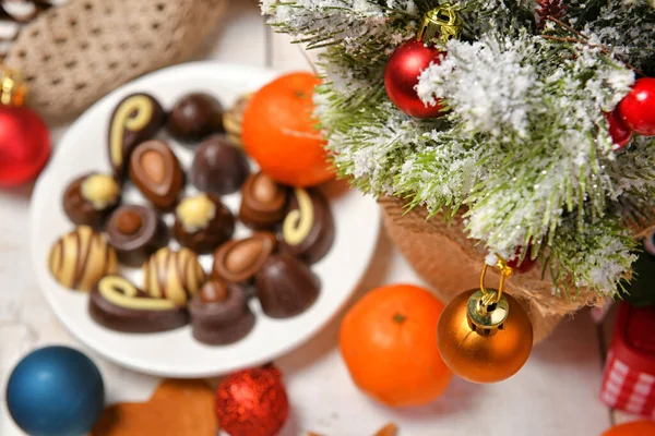 甘いフードトップビューの背景メリークリスマスや新年の休日の装飾のための チョコレートキャンディー みかん 白い木のクッキー — ストック写真