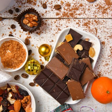 Mutlu noeller ya da yeni yıl dekorasyonu için tatlı yemek üst görünümü - çikolata şekerler, mandalinalar, beyaz ahşap üzerinde kurabiyeler