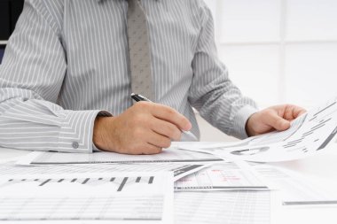 İş dünyası konsepti - iş adamının çalışma masası yakın görünümü, mali raporları kontrol etmesi, yazması ve sayması