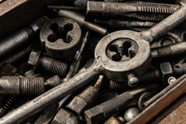 Arka plan olarak matkaplar ve iplikçiklerle dolu eski vintage demir alet kutusu