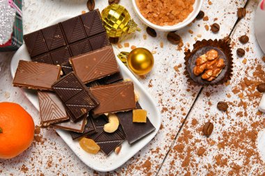 Mutlu noeller ya da yeni yıl dekorasyonu için tatlı yemek üst görünümü - çikolata şekerler, mandalinalar, beyaz ahşap üzerinde kurabiyeler